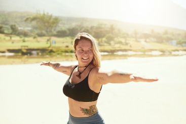 Seaside, woman and smile for stretching with yoga for...