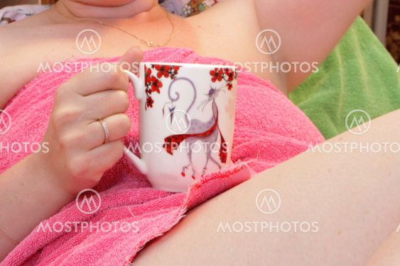 Woman with a cup of coffee in pink towel