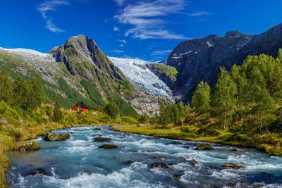 Norwegian landscape with milky blue glacier river,...
