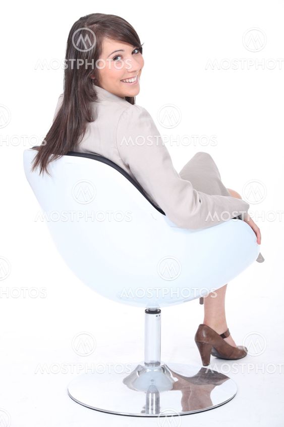 Happy young businesswoman in a swivel chair