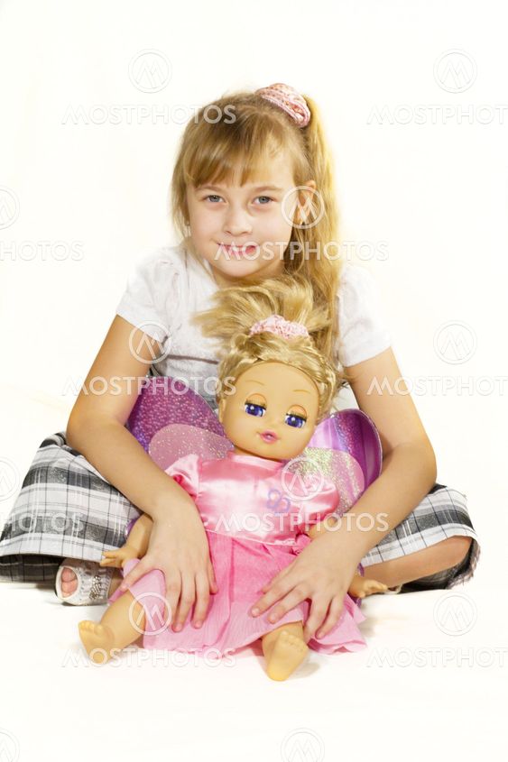 Beautiful little girl playing with a doll.