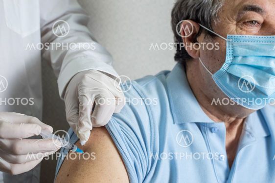 Doctor holding syringe with Covid-19 or coronavirus...