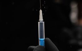 doctor holding a syringe with a needle. doctor holding a...