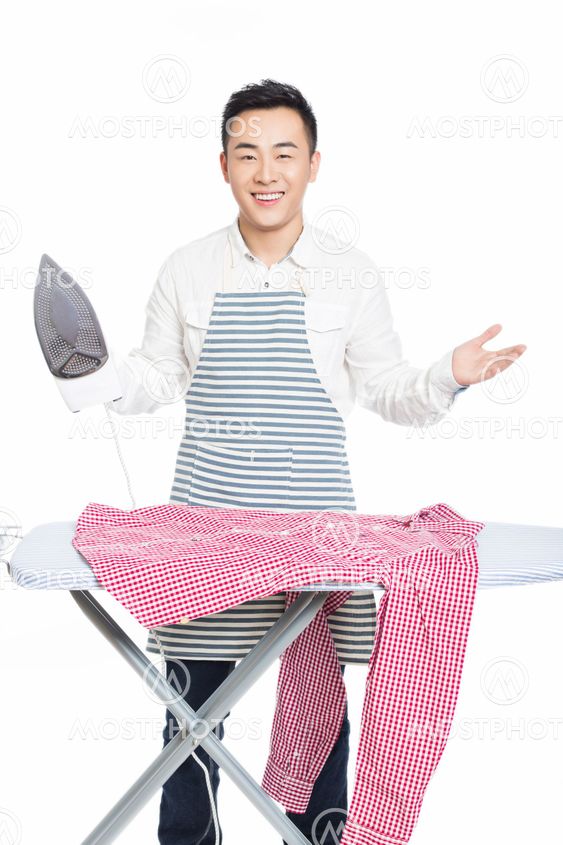 chinese young man ironing his clothes