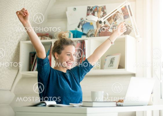 Portrait of an attractive woman at the table with cup and laptop