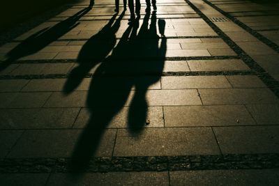 Silhouettes of people walking on city street