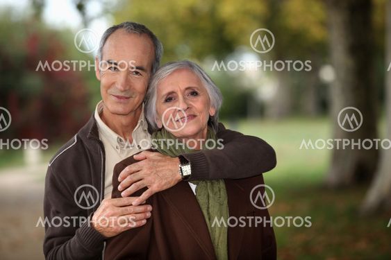 Old couple walking through park
