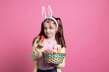 Cheerful lovely kid showing colorful easter decorations...