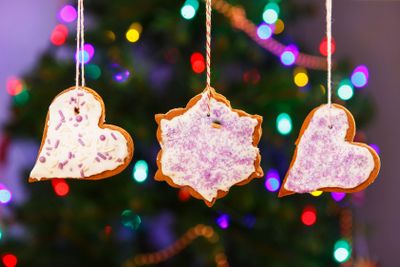 Gingerbread cookies hanging with Christmas tree on...