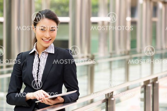 Chinese Businesswoman Working On Tablet Computer Outside Office