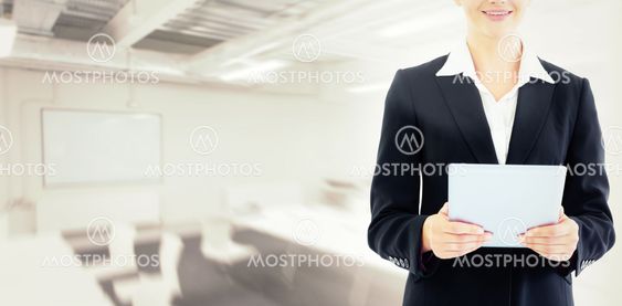 Composite image of businesswoman holding tablet