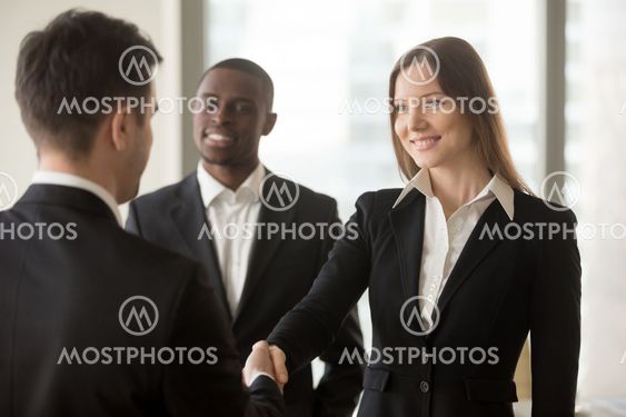 Beautiful smiling businesswoman and businessman handshaking, fir