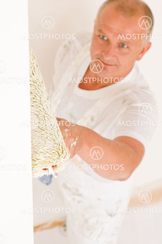Home decorating mature man painting wall roller