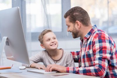 father and son with desktop computer