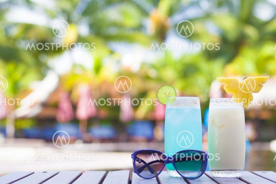 two cocktails near tropical pool