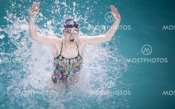 Woman athlete swimming crawl stroke in pool.