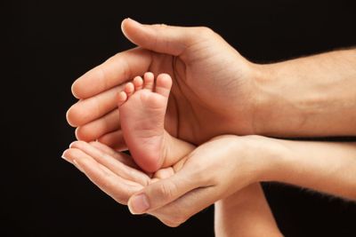 Newborn baby foot in parents hands