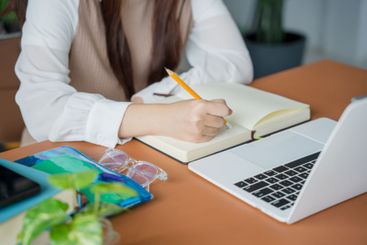 Asian woman using laptop to study student engaged in...