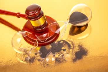 A traditional gavel with a gold band sits next to a...