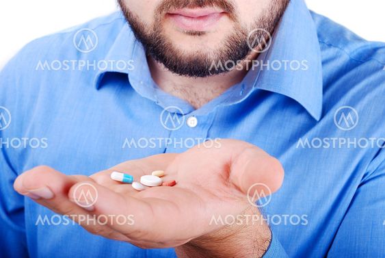 Man's palm with medicine pills on