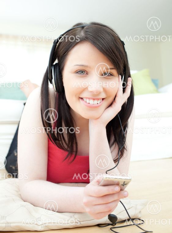 Cheerful woman listening music with headphones on