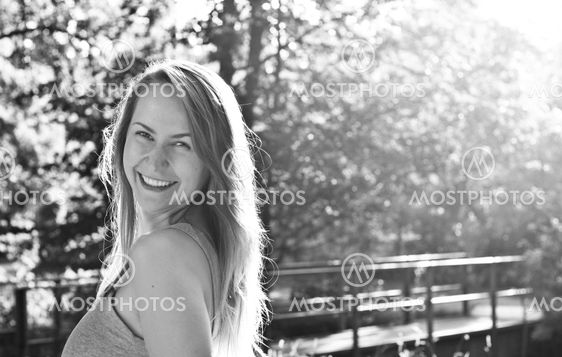 Smiling blond young woman in a park