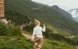 Girl hiking on trail by cabin