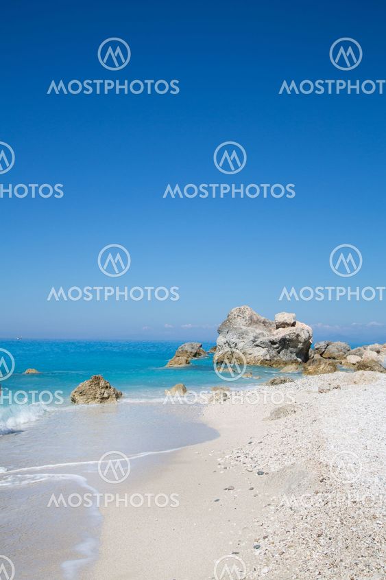 White sand beach with clear blue sky in Greece for a background