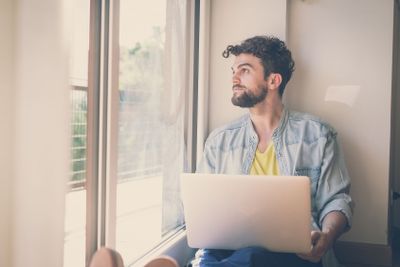 handsome hipster modern man working home using laptop