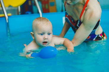Baby boy swimming in the pool. Swimming pool for babies...
