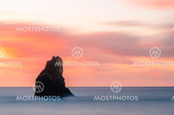 Rock formation in sea at sunrise