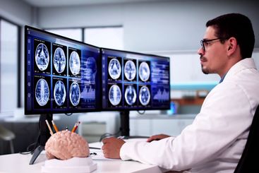 Doctors In Clinic Looking At Brain MRI Scan