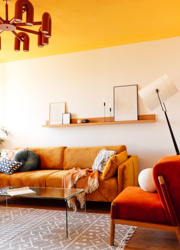 Stylish sofa made of orange soft fabric with contrasting...