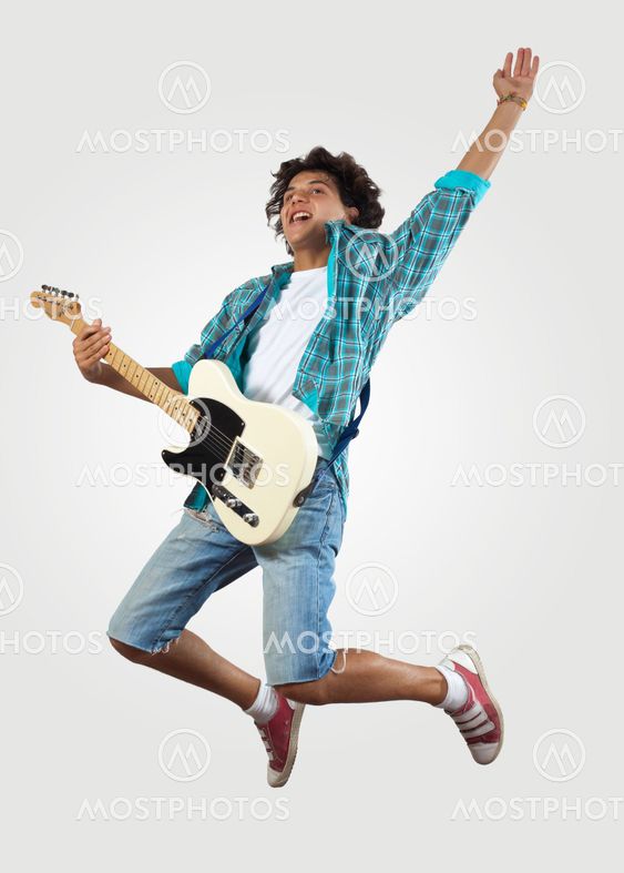 young man playing on electro guitar and jumping