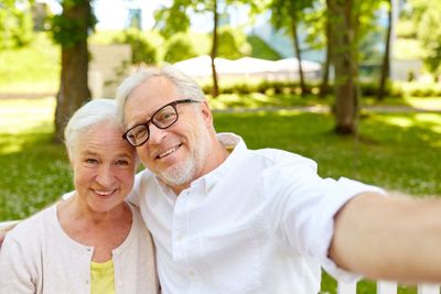 senior couple taking selfie at summer park 