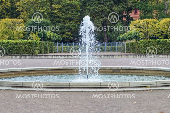 Circle fountain with colorful autumn trees on background