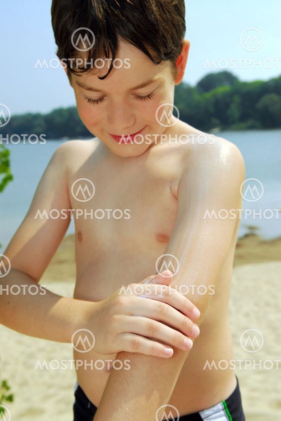 Boy applying sunscreen