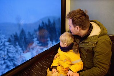 Family looking out of the window of train during travel...