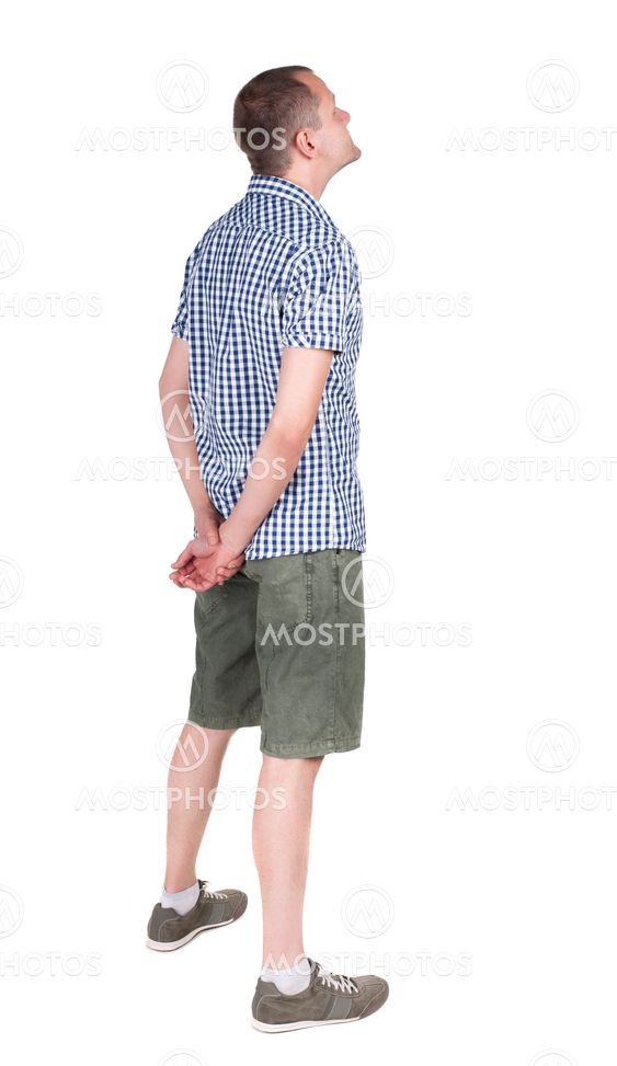 Back view of adult man in shirt and shorts looking.