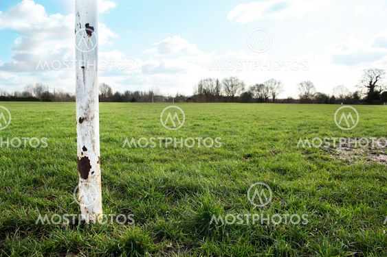 A Close Up Of A Goal Post On A Field In The Sun With Blue Sky And Clouds