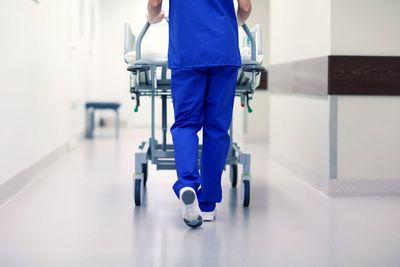 nurse carrying hospital gurney to emergency room