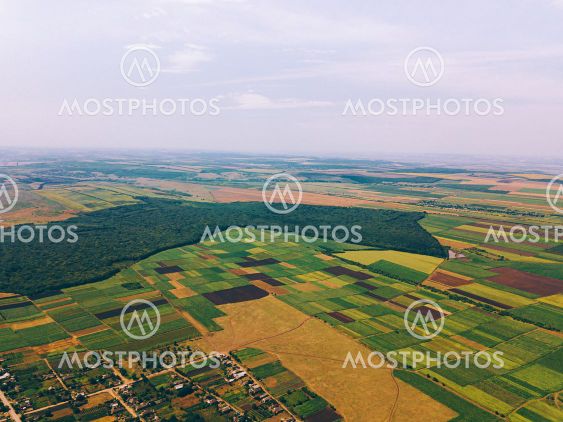 Photo made with drone above village near crop fields in...