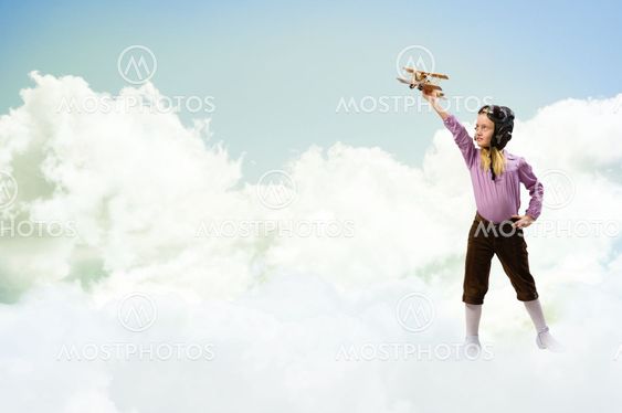 girl in helmet pilot playing with a toy airplane
