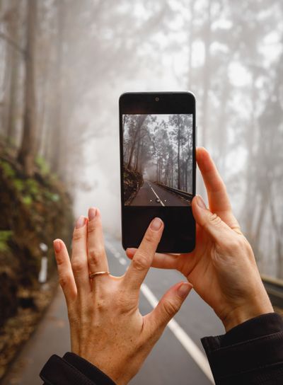 Making atmosphere photo of the misty road via mobile phone.