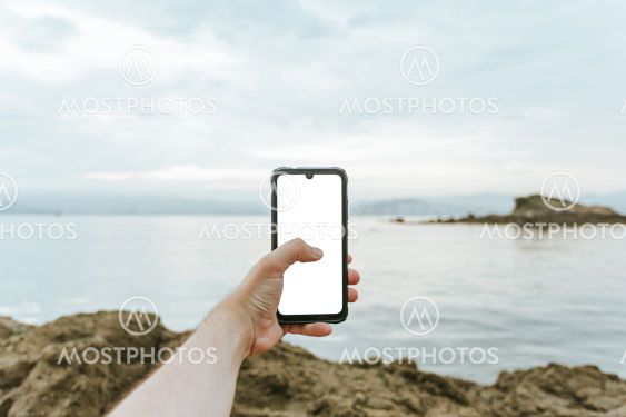 Young male hand grabbing a phone with copy space with...