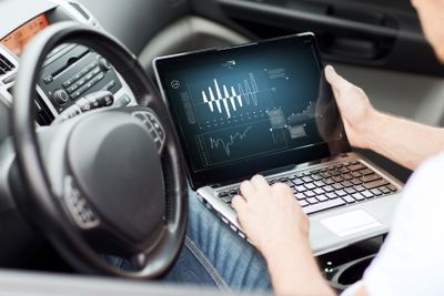 man using laptop computer in car