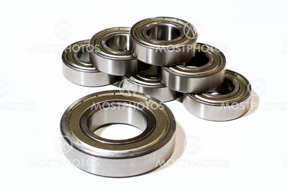 Many bearings of different sizes together. White background.