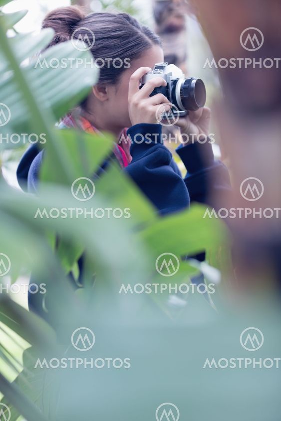 Young woman taking a picture in a wooded area