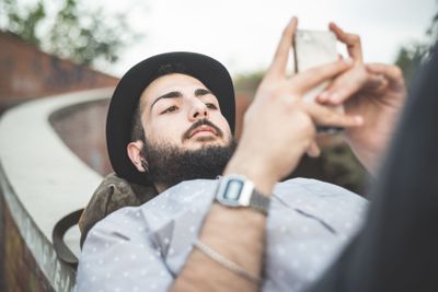young handsome hipster gay modern man using smartphone