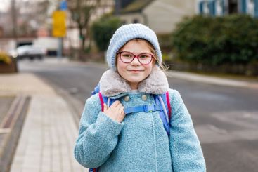 Cute little girl o the way to or from school. Healthy...